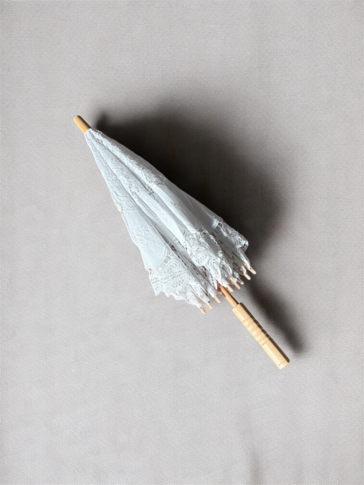 Ombrelle décorative en dentelle personnalisable pour mariage, accessoire chic et intemporel pour cérémonie et photos.
