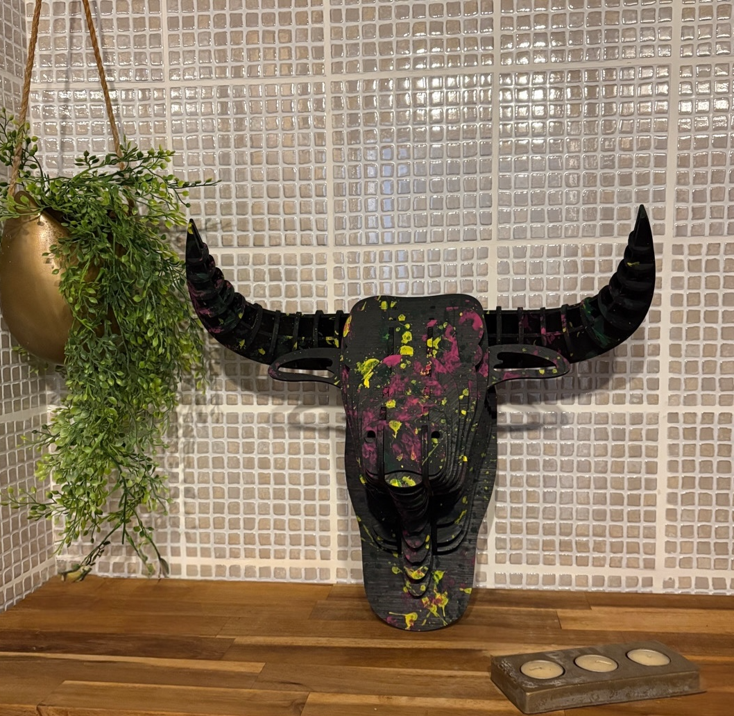 Tête de taureau décorative en relief noir avec taches de peinture colorée 